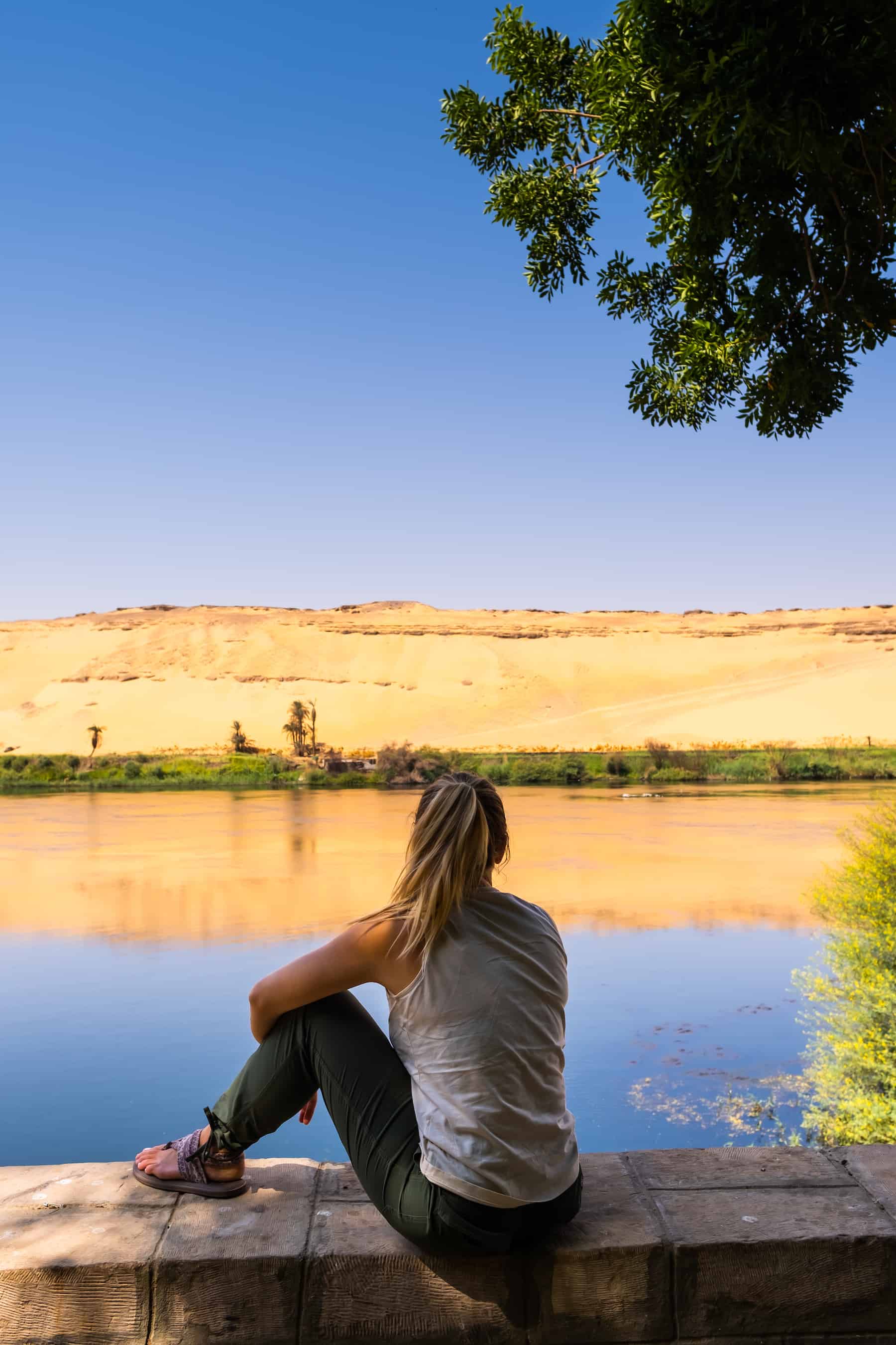 Natasha zit langs de oevers van de Nijl in Aswan