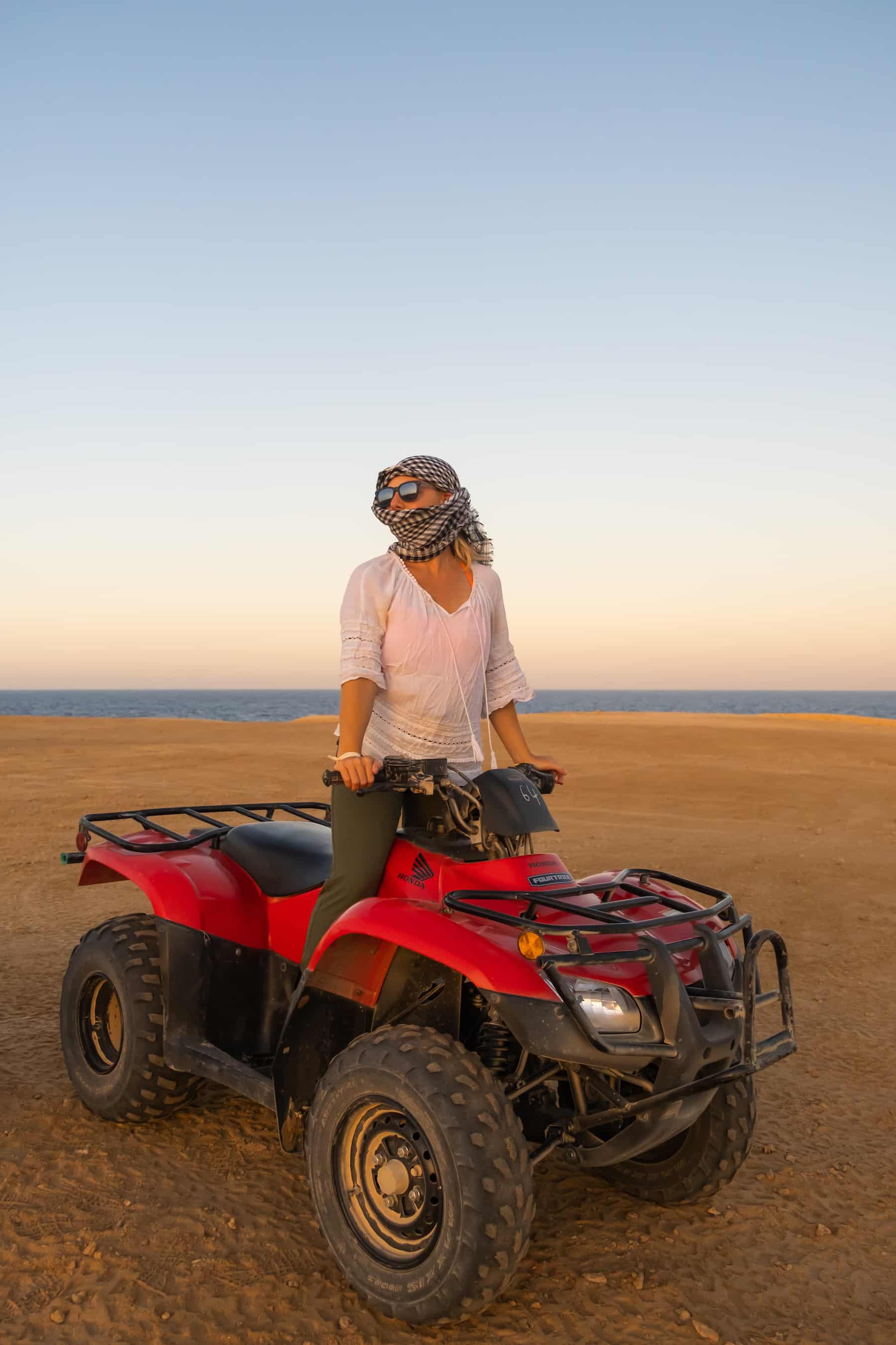 Natasha uses a scarf to cover her face from dust in Egypt