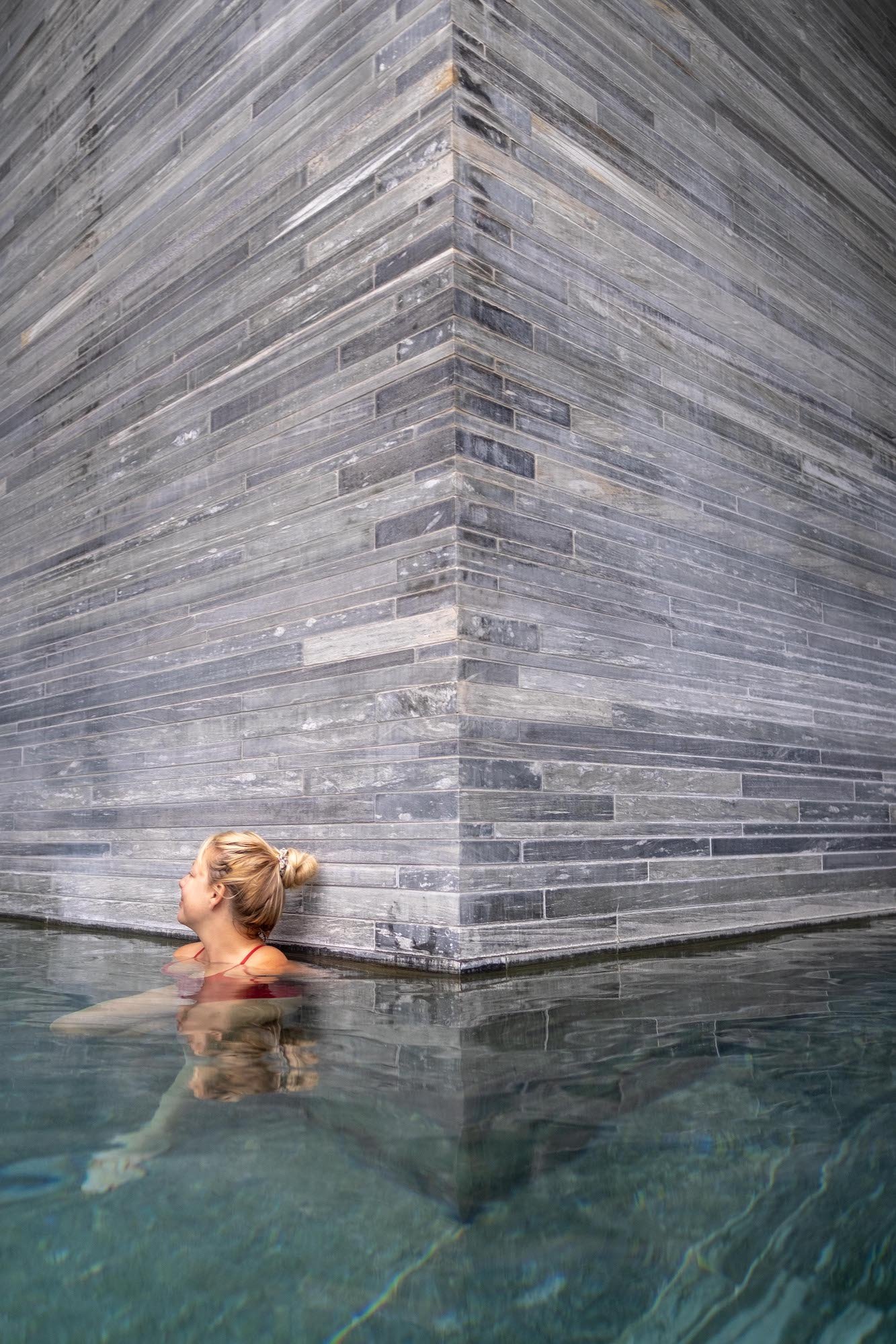 Tasaha soaking along quartzite wall in Therme Vals 